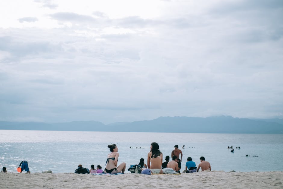 A serene beach scene with people enjoying the sun, sand, and sea