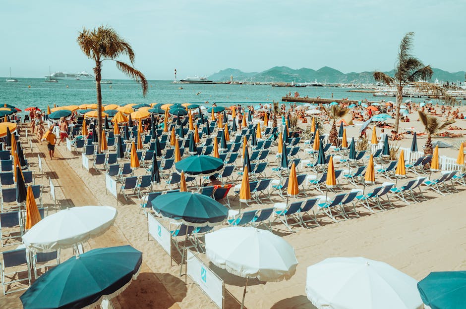 Vibrant beach scene with colorful umbrellas, chairs, and people relaxing by the sea